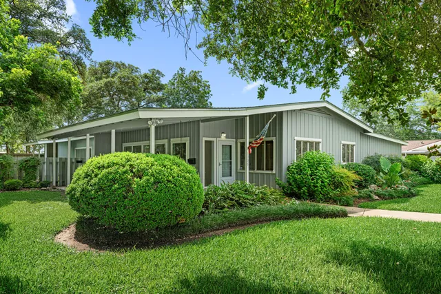 a view of a house with a yard and potted plants