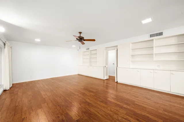 a view of empty room with wooden floor