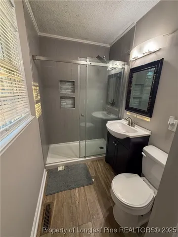 a bathroom with a sink a toilet a mirror and shower