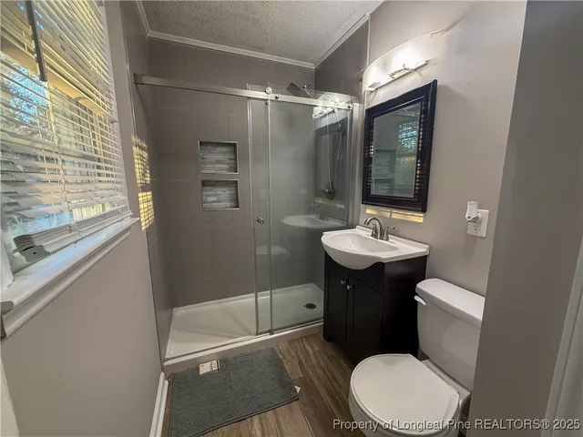 a bathroom with a sink a toilet a mirror and shower