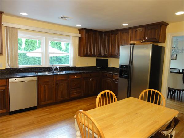 156 Pleasant Street Lexington, MA 02421 - Photo 11 of 28 a kitchen with stainless steel appliances granite countertop a refrigerator a sink a stove a dining table and chairs