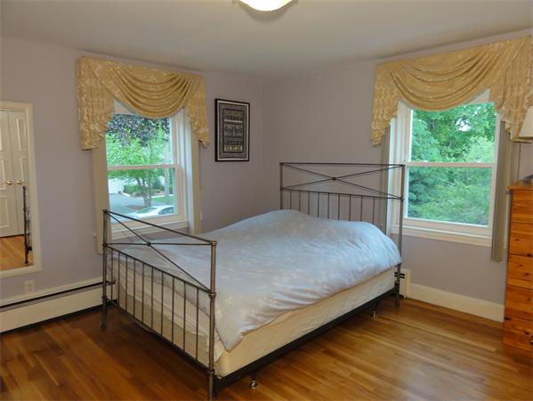156 Pleasant Street Lexington, MA 02421 - Photo 17 of 28 a bedroom with a bed and wooden floor