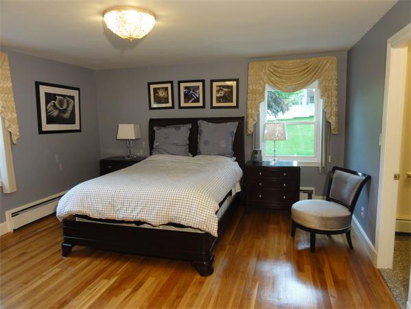 156 Pleasant Street Lexington, MA 02421 - Photo 18 of 28 a bedroom with a bed and a chair