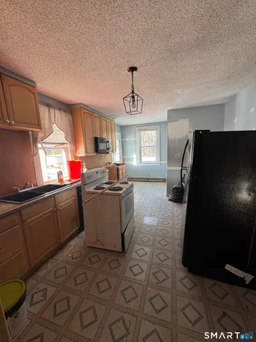 a kitchen with a sink a refrigerator and a stove