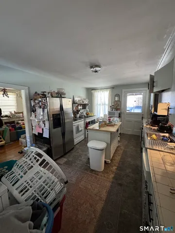a living room with stainless steel appliances kitchen island granite countertop a sink stove and cabinets