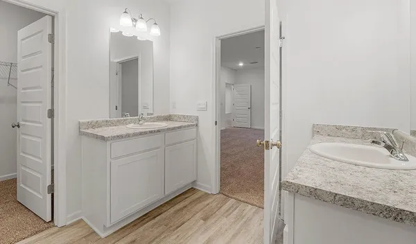 a bathroom with a granite countertop sink a mirror and a shower