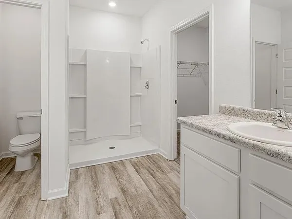 a bathroom with a sink a toilet and shower