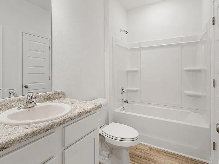 42 Woodsorrel Street Freeport, FL 32439 - Photo 18 of 20 a bathroom with a granite countertop sink toilet and shower