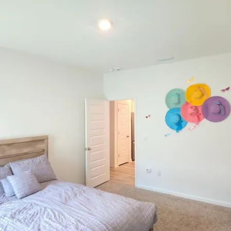a bedroom with a bed and painting on the wall