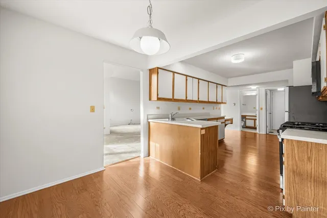 a kitchen with wooden floors and white cabinets