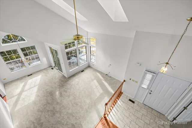 a view of an empty room with furniture and staircase