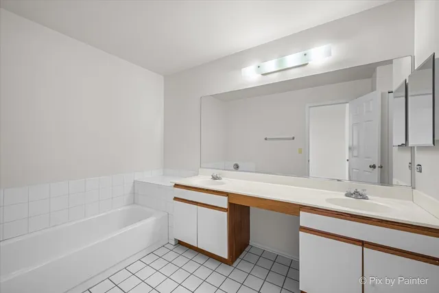a bathroom with a sink double vanity granite tub and a mirror