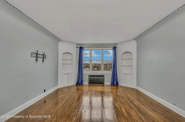a view of empty room with a kitchen