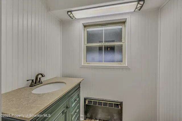 a bathroom with a granite countertop sink vanity and mirror