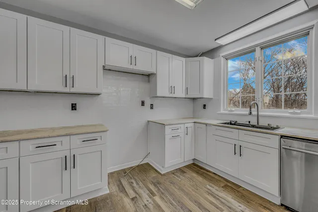 a kitchen with white cabinets and white appliances