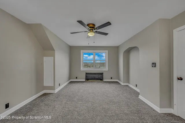 a view of a livingroom with a ceiling fan and window