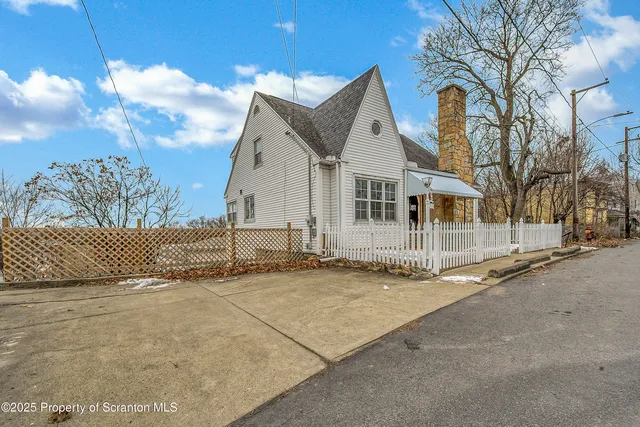 a view of a white house with a street
