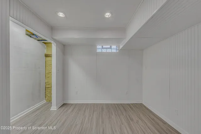 a view of an empty room with wooden floor and closet