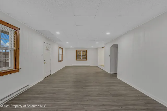 a view of a big room with wooden floor and windows