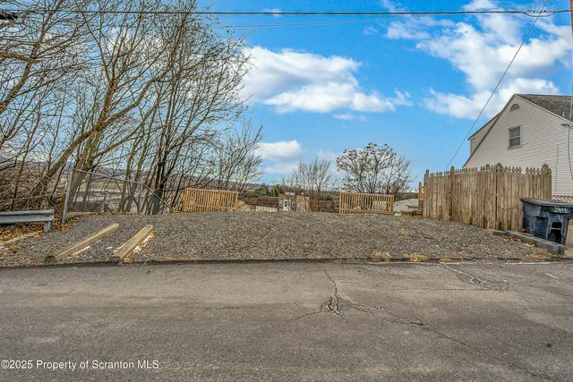 a view of a yard with wooden fence