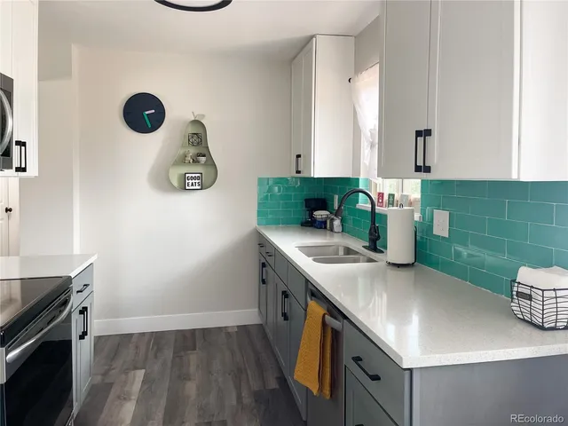 a kitchen with a sink cabinets and wooden floor