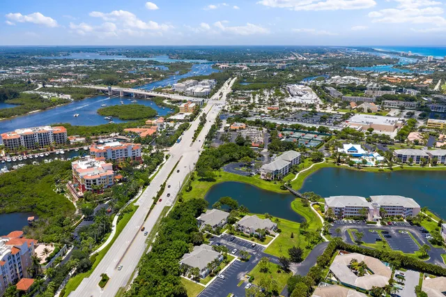 an aerial view of a city with lots of residential buildings ocean and mountain view in back