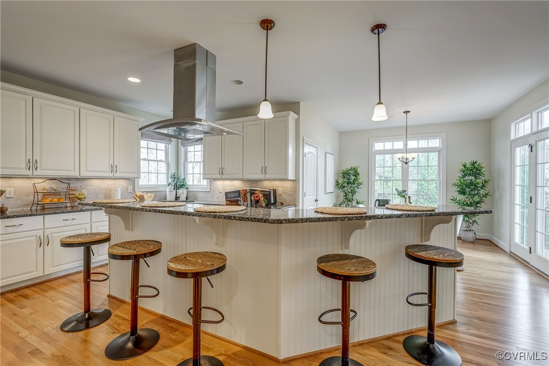 3412 Handley Road Midlothian, VA 23113 - Photo 17 of 50 a kitchen with stainless steel appliances granite countertop a stove a sink a table and chairs with wooden floor