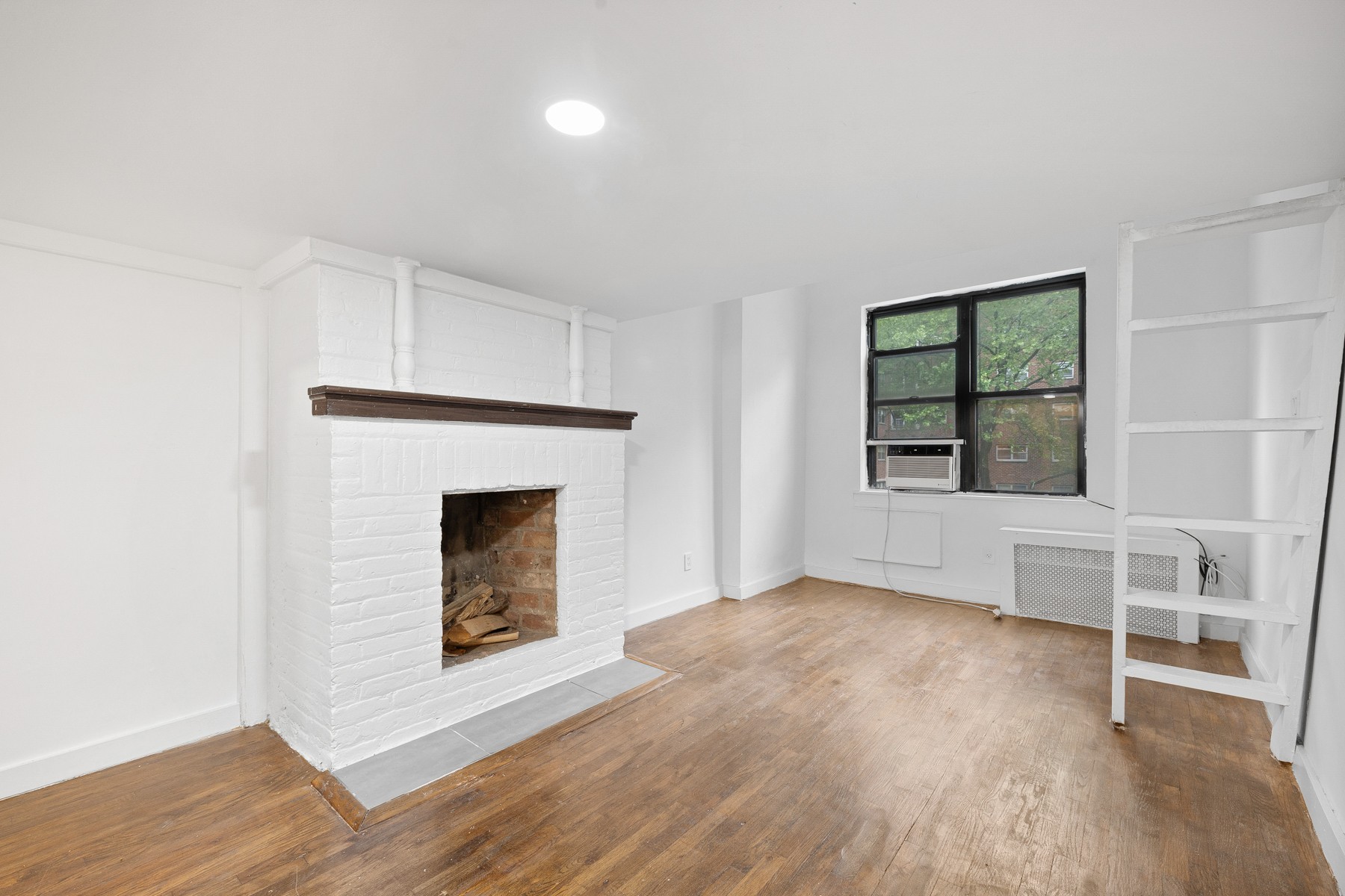 an empty room with windows and fireplace