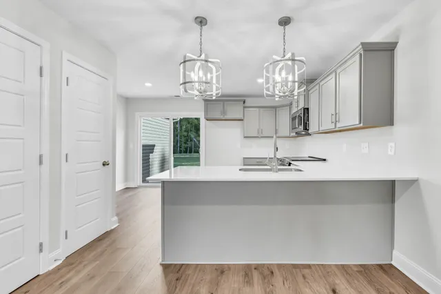 a view of a kitchen counter space a sink and wooden floor