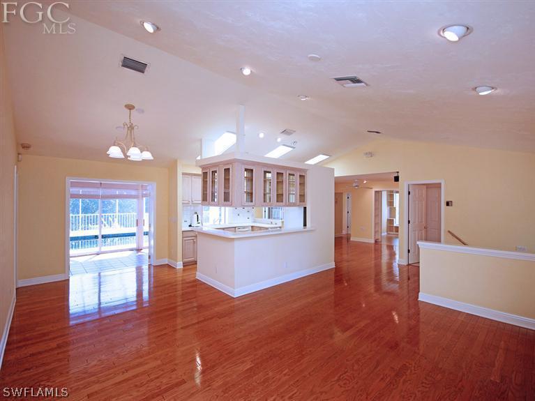 916 Beach Road Sanibel, FL 33957 - Photo 7 of 14 a open kitchen with white cabinets and wooden floor