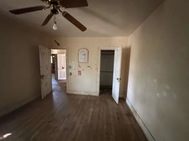 en empty room with wooden floor table and chairs