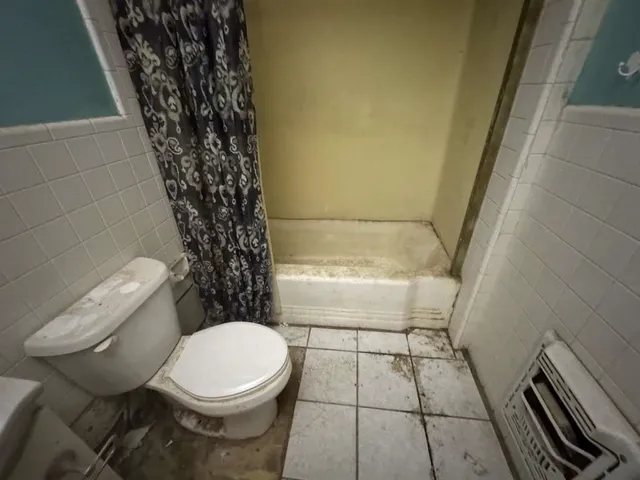 a bathroom with a toilet and a shower