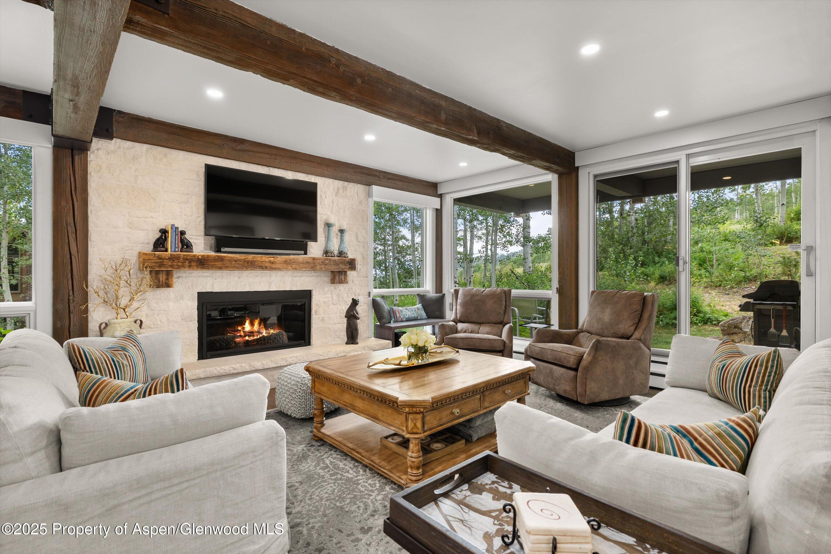a living room with furniture fireplace and a large window