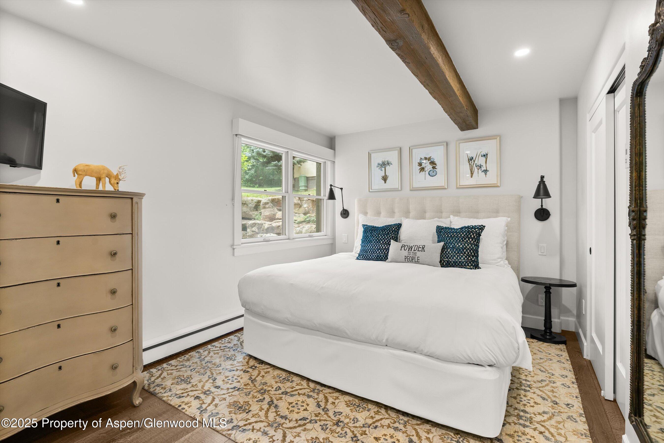 855 Carriage Way, Unit 103 Snowmass Village, CO 81615 - Photo 12 of 26 a bedroom with a bed and a flat tv screen