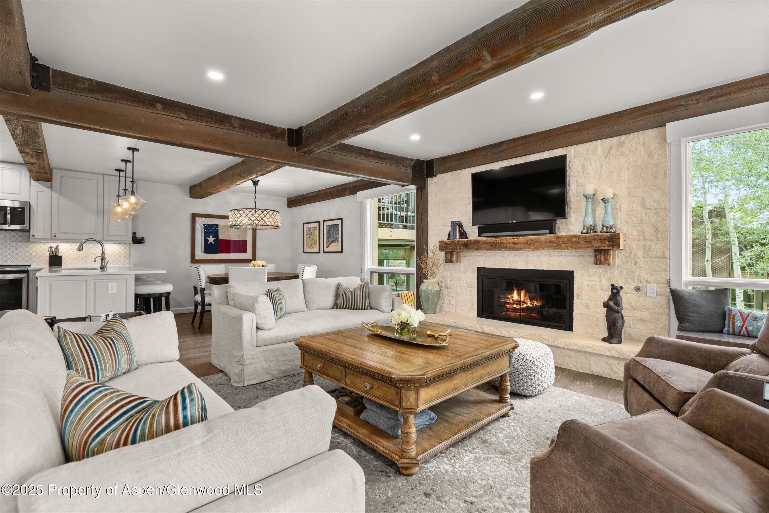 855 Carriage Way, Unit 103 Snowmass Village, CO 81615 - Photo 17 of 26 a living room with furniture a flat screen tv and a fireplace