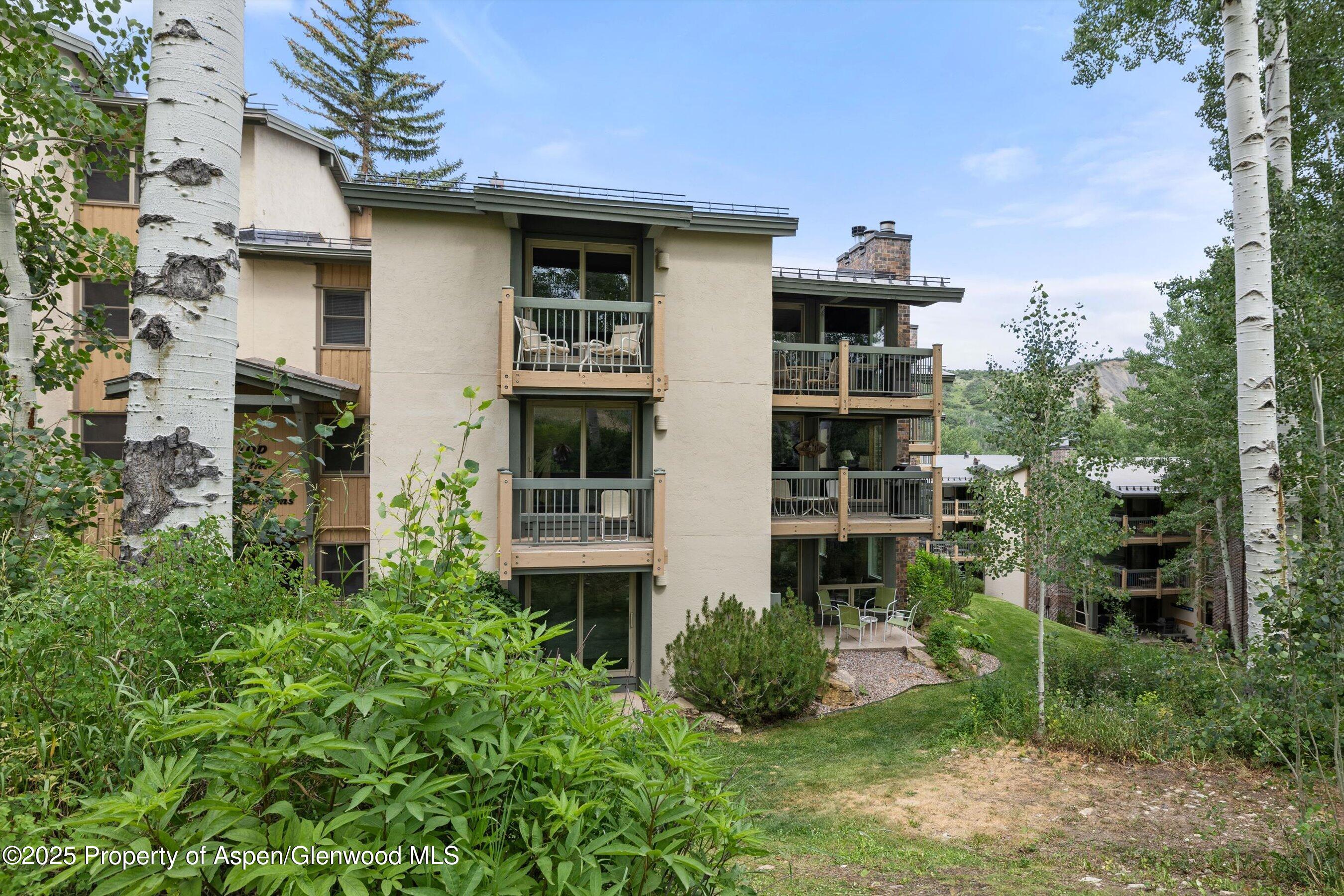 855 Carriage Way, Unit 103 Snowmass Village, CO 81615 - Photo 19 of 26 a front view of a house with a garden