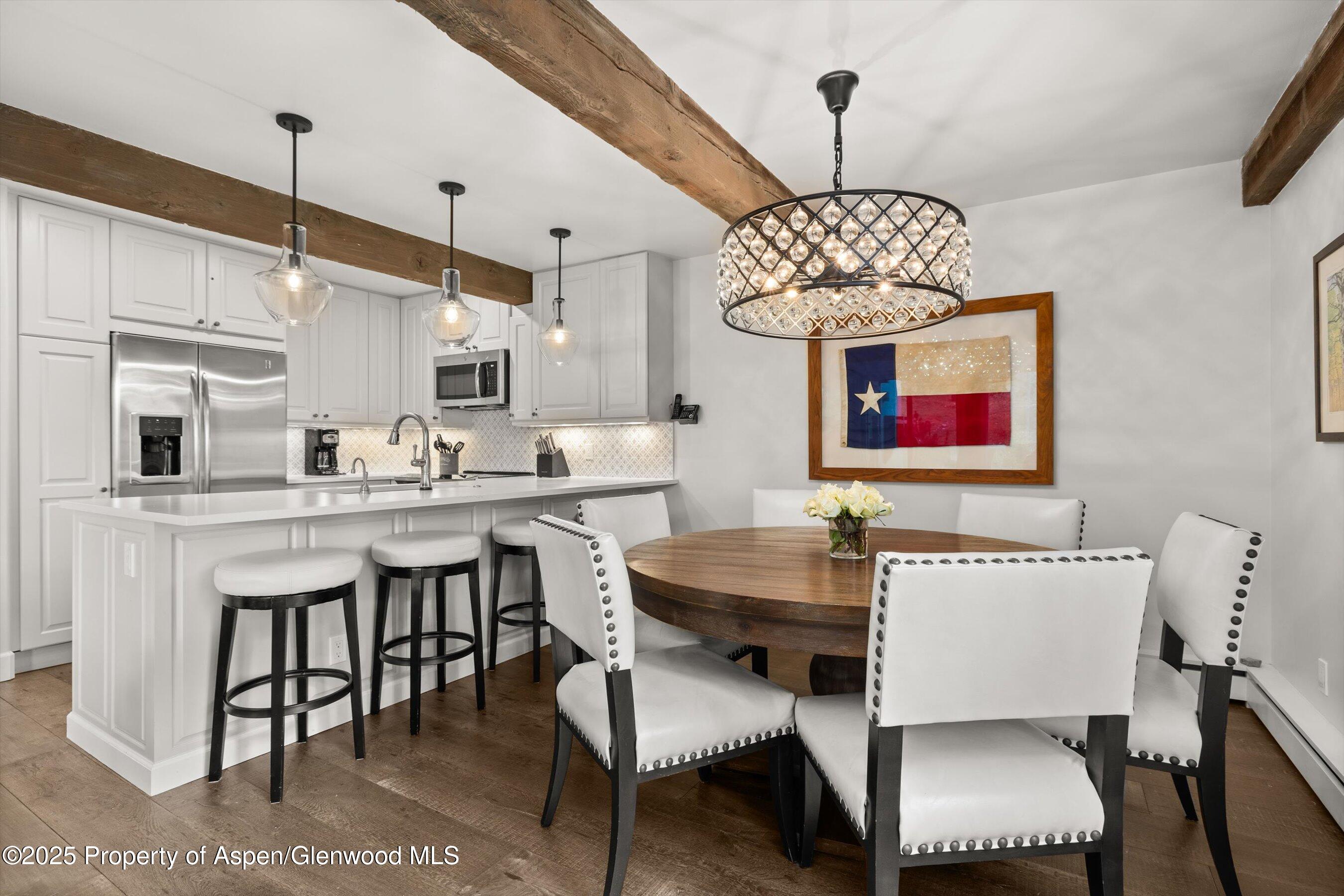 855 Carriage Way, Unit 103 Snowmass Village, CO 81615 - Photo 6 of 26 a dining room with furniture a chandelier and window