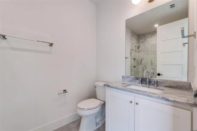 a bathroom with a granite countertop sink a toilet and a mirror