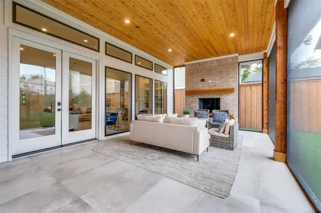a living room with furniture floor to ceiling window and a flat screen tv