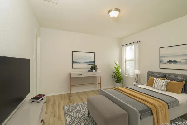 a bedroom with a bed and a flat tv screen on a dresser