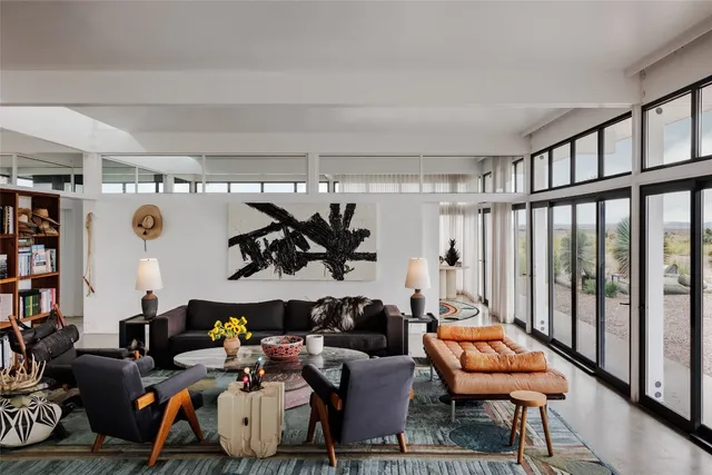 a living room with lots of furniture and a potted plant