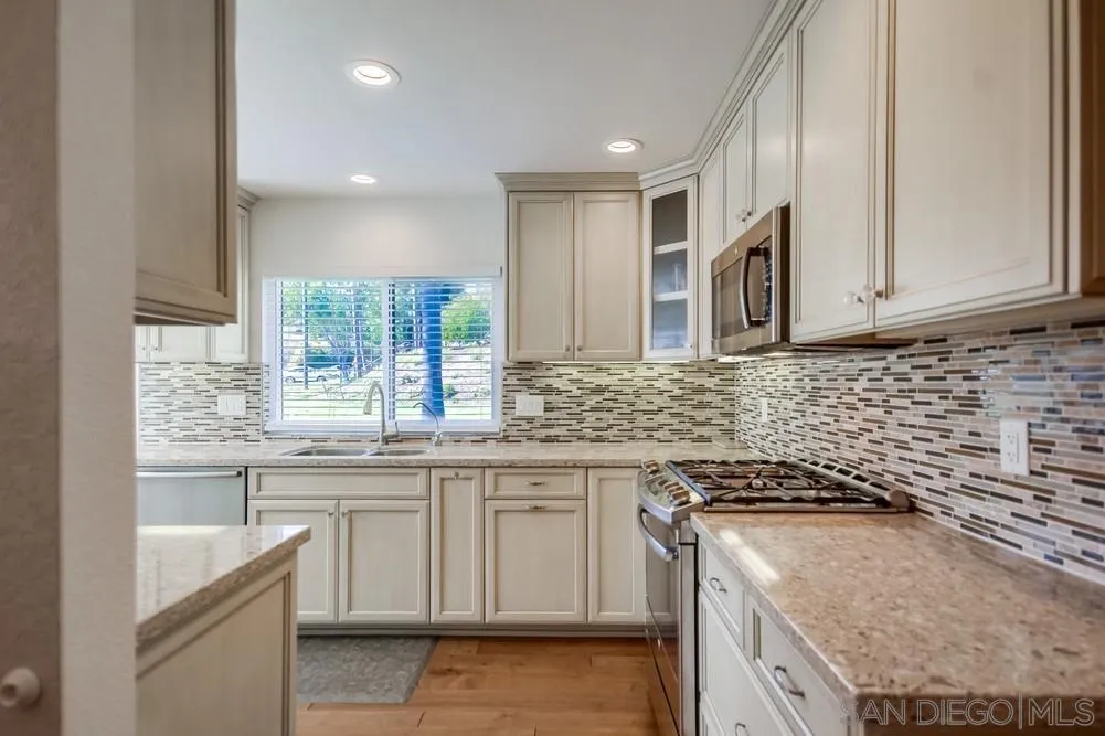 3797 Fallon Circle San Diego, CA 92130 - Photo 11 of 37 a kitchen with granite countertop a sink stove and cabinets