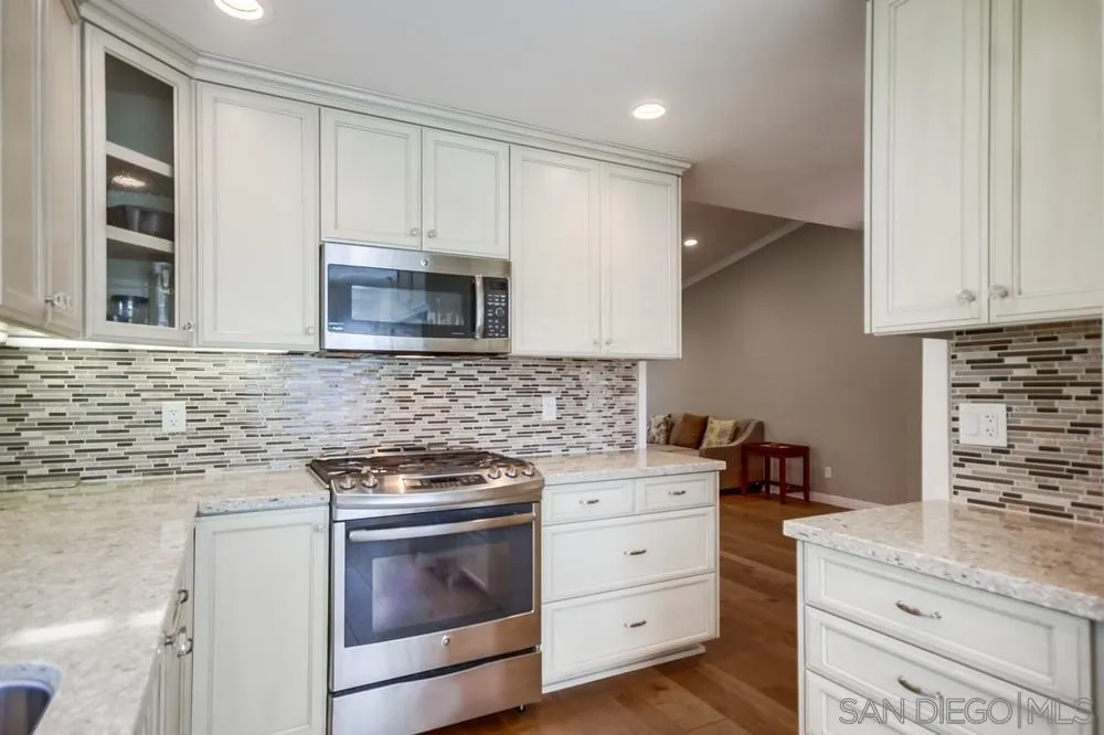 3797 Fallon Circle San Diego, CA 92130 - Photo 14 of 37 a kitchen with granite countertop white cabinets and stainless steel appliances
