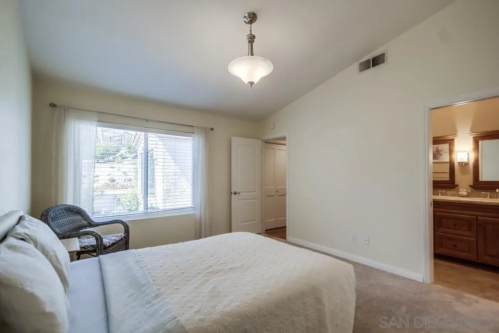 3797 Fallon Circle San Diego, CA 92130 - Photo 23 of 37 a bedroom with a bed and a chandelier
