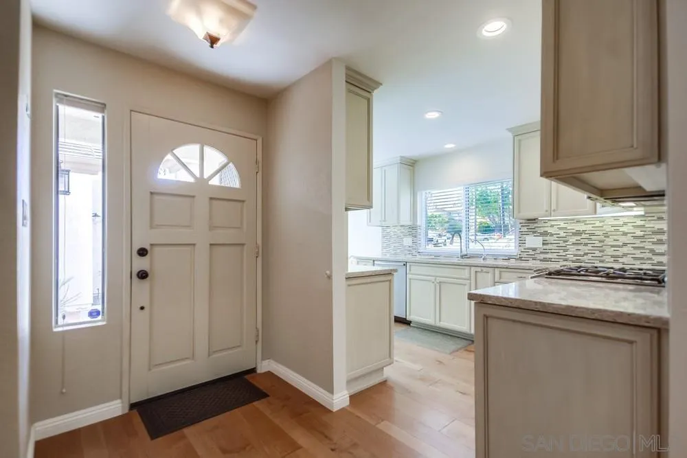 3797 Fallon Circle San Diego, CA 92130 - Photo 9 of 37 a kitchen with kitchen island granite countertop white cabinets and white appliances