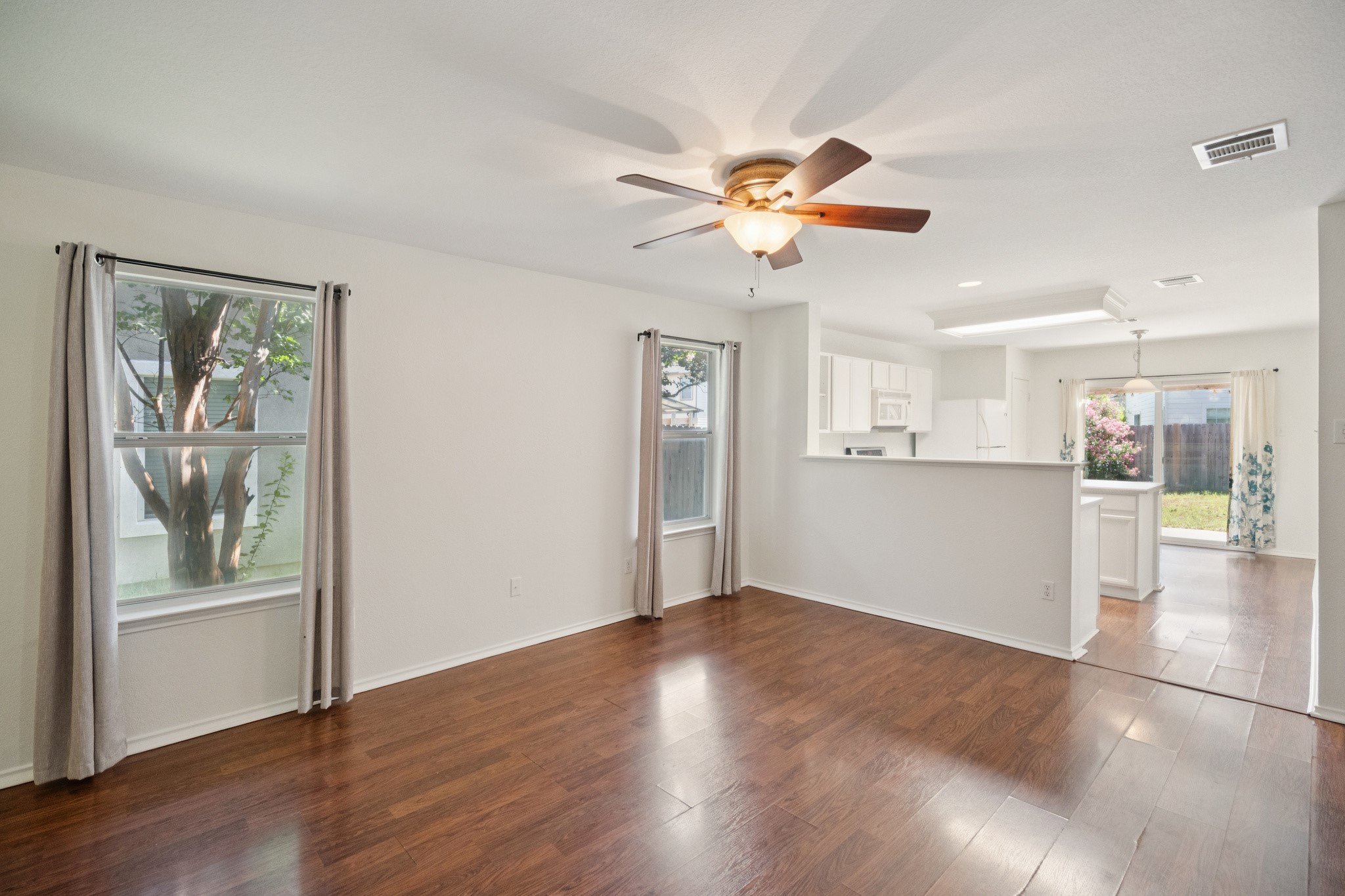 77 Jan Lane Georgetown, TX 78626 - Photo 11 of 16 An inviting open-concept living space features warm wood flooring and a bright kitchen.