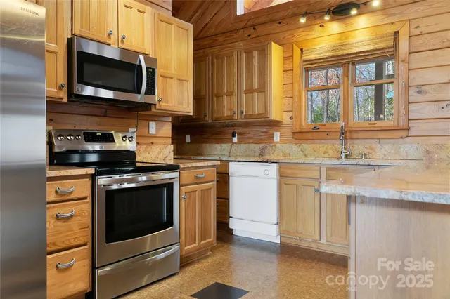 a kitchen with stainless steel appliances granite countertop a stove a microwave and a sink