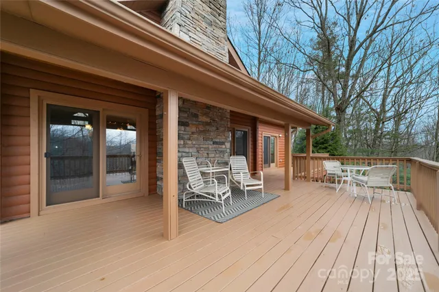 a view of a patio with table and chairs and floor to ceiling window with wooden floor