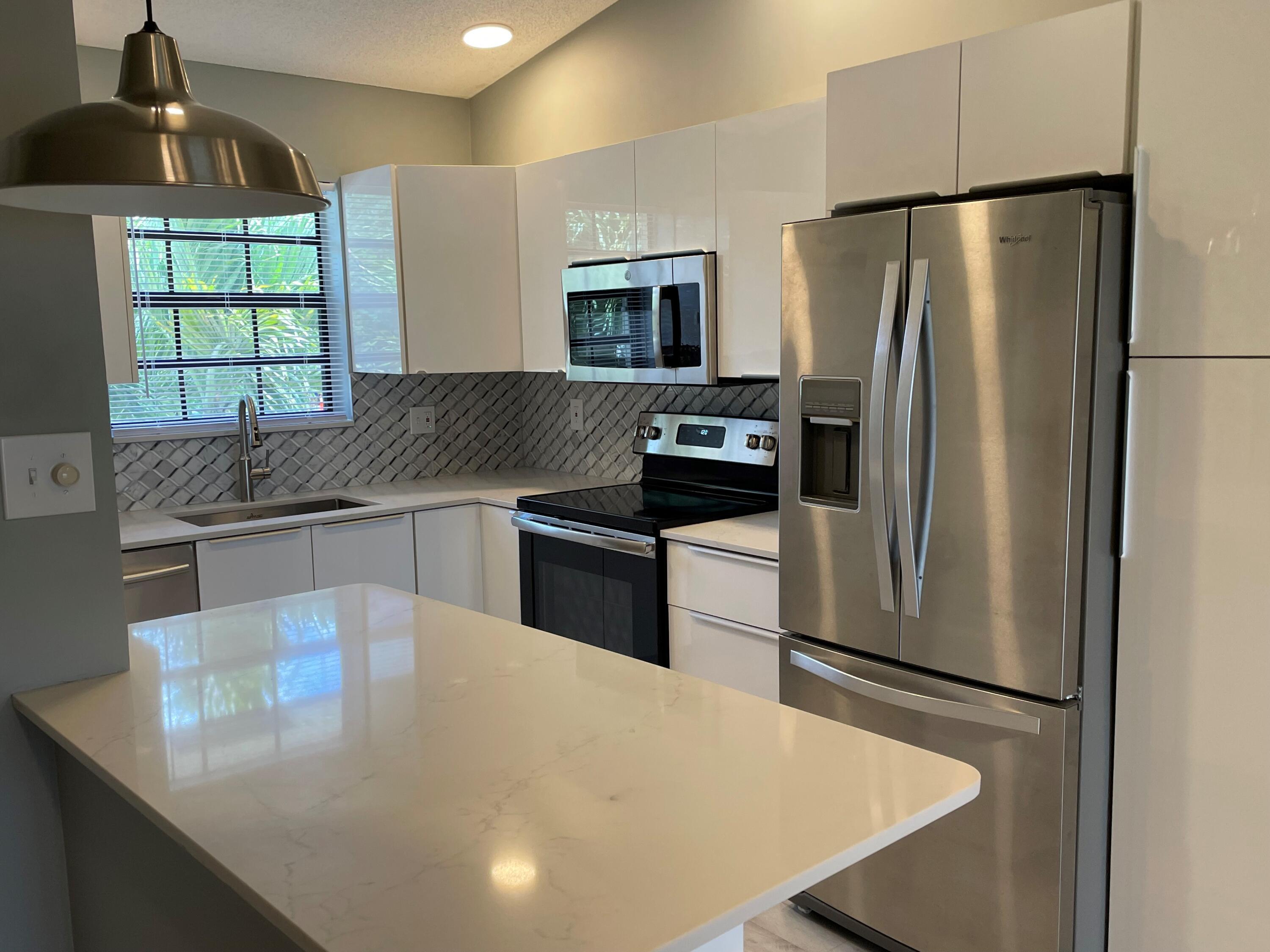 a kitchen with stainless steel appliances a refrigerator a stove a sink and a counter