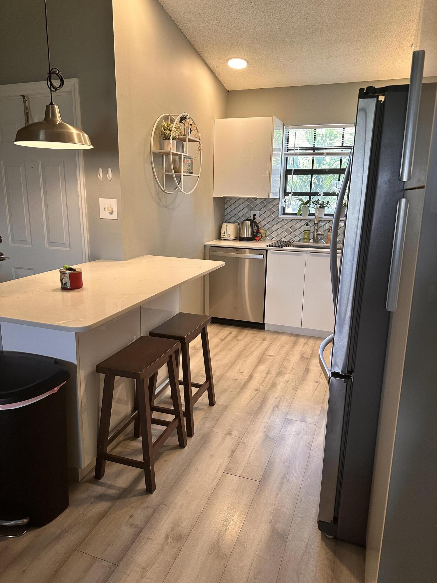 2800 Palmwood Terrace, Unit P221 Boca Raton, FL 33431 - Photo 4 of 16 a kitchen with stainless steel appliances kitchen island granite countertop a sink refrigerator and microwave